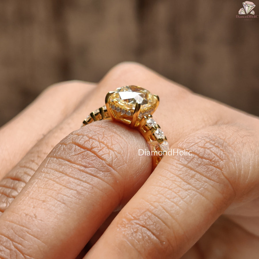 Cushion Cut Moissanite Wedding Ring in gold setting with side stones worn on finger by Diamond Holic