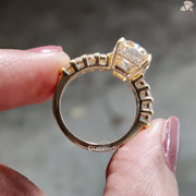 Gold Cushion Cut Moissanite Wedding Ring held between fingers showing side profile details