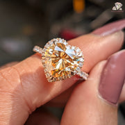 Close-up of a person's hand holding a diamond ring with a blurred background