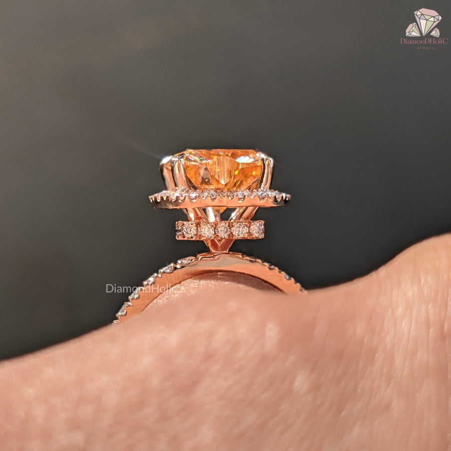 Rose gold ring with a large orange gemstone on a dark background