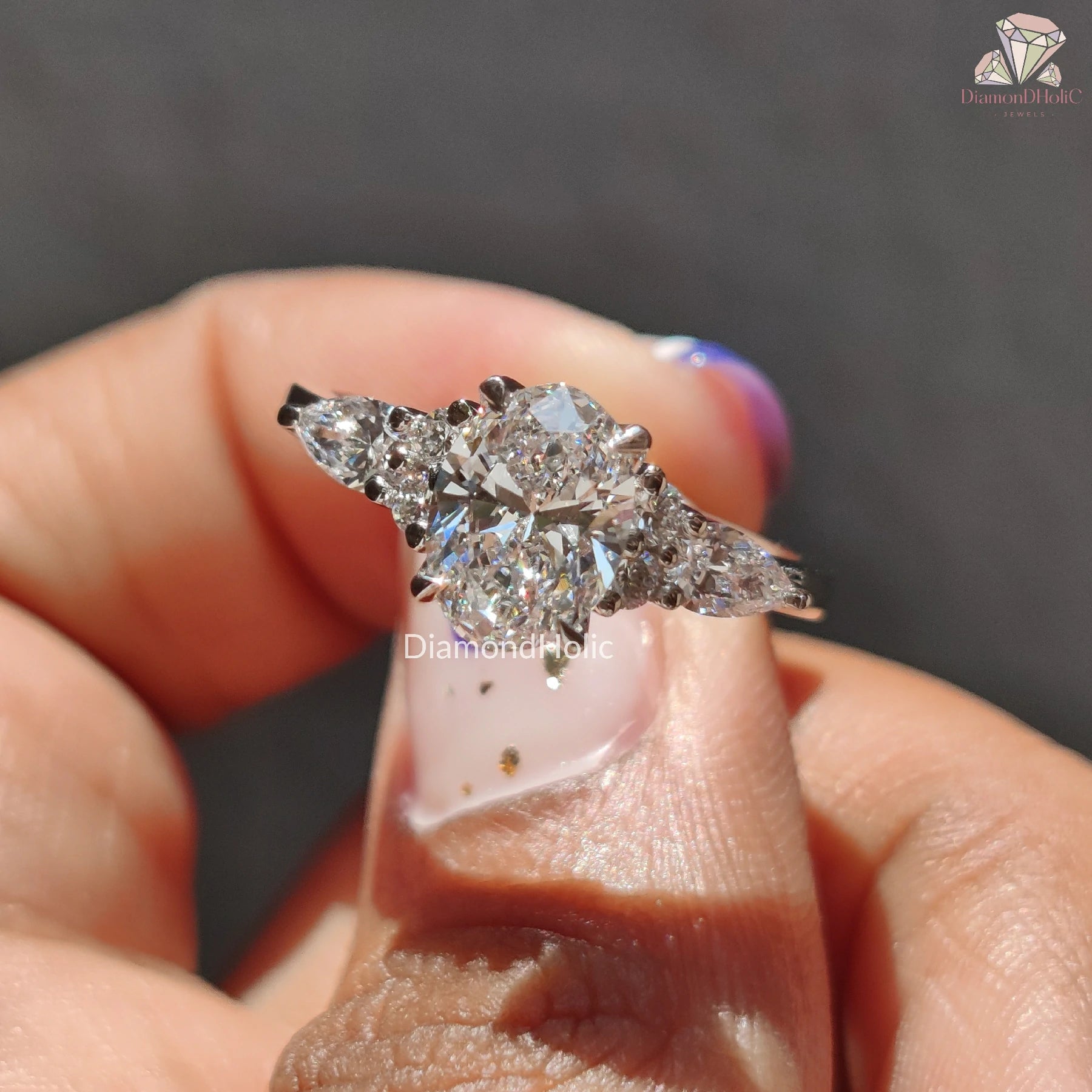 oval lab diamond | white metal ring | pear shaped side stones
