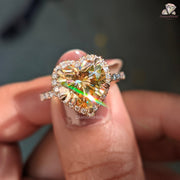 Close-up of a hand holding a diamond ring with a multicolored gemstone.

